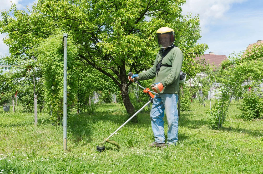 Gärtner mit Schutzausrüstung bei der Gartenarbeit